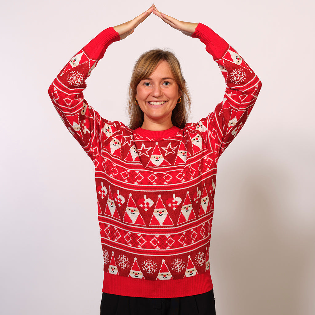 Une femme posant avec un pull rouge de Noël orné de lutins.
